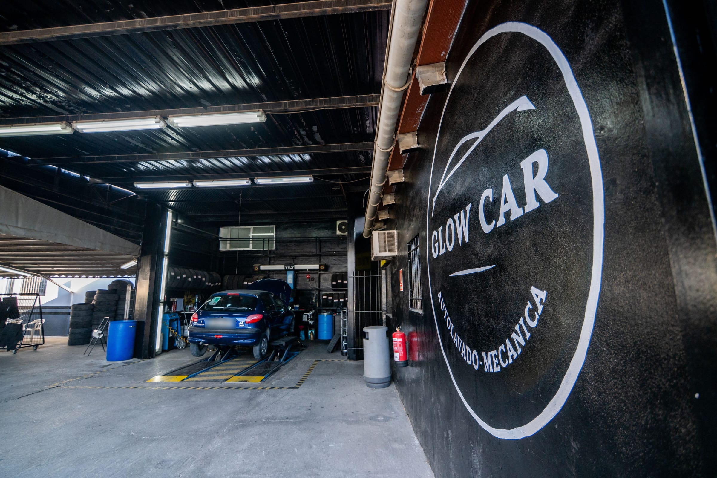 Logotipo de Glow Car pintado en la pared del taller de Villena